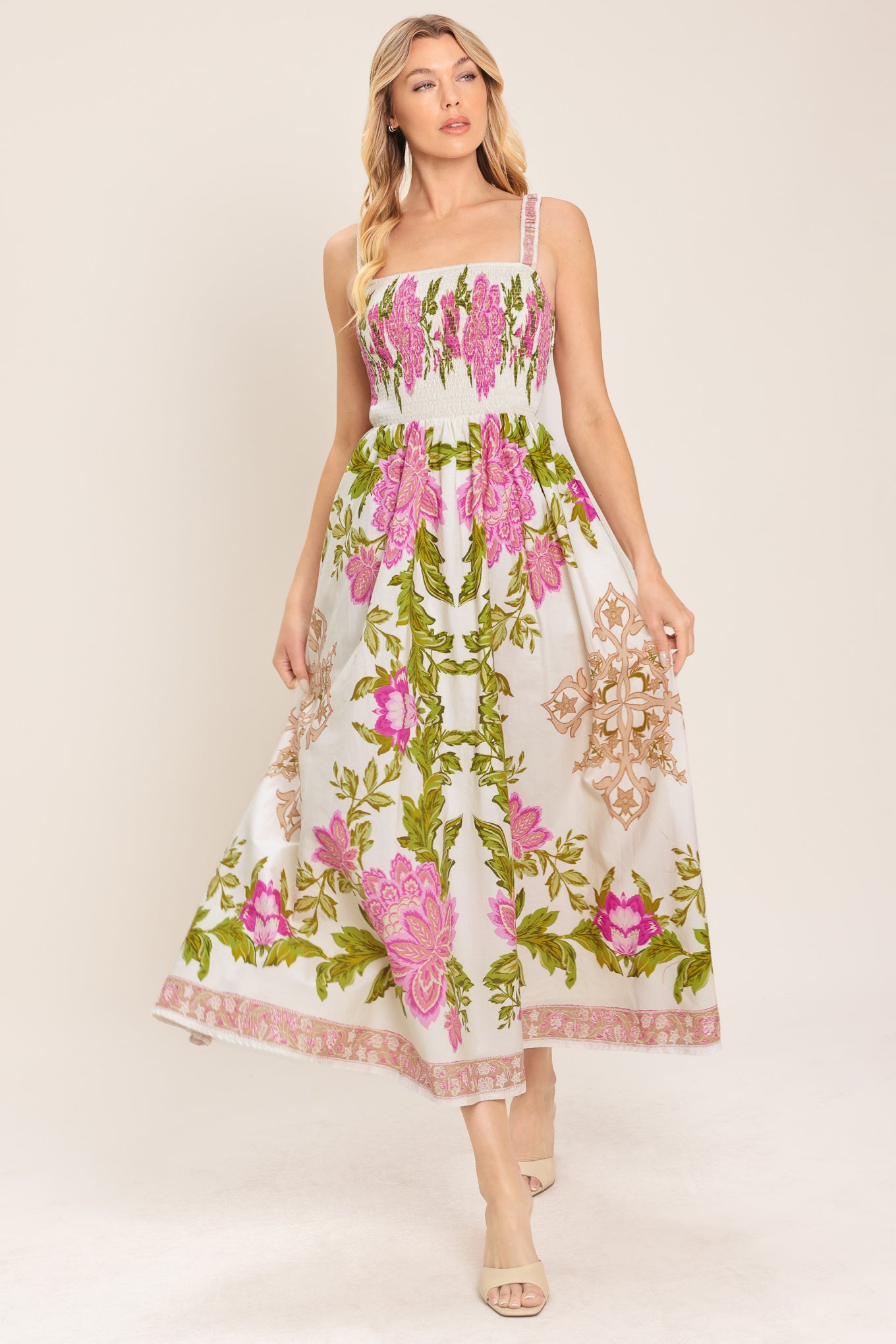 Woman wearing an ivory floral midi dress with pink flowers and green leaves and geometric detail | Flying Tomato