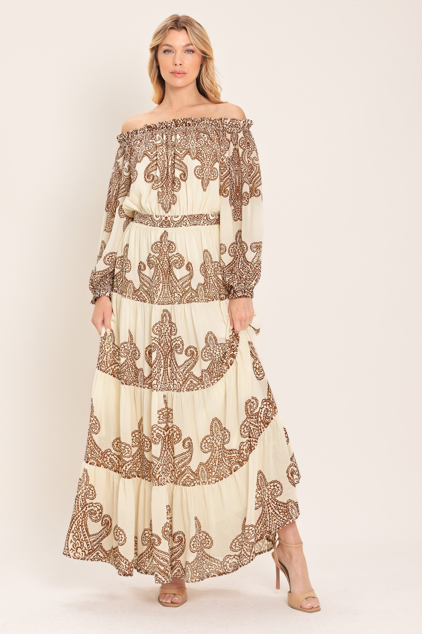 Woman wearing an off-shoulder maxi dress with intricate brown embroidery featuring a smocked back waistband | Flying Tomato
