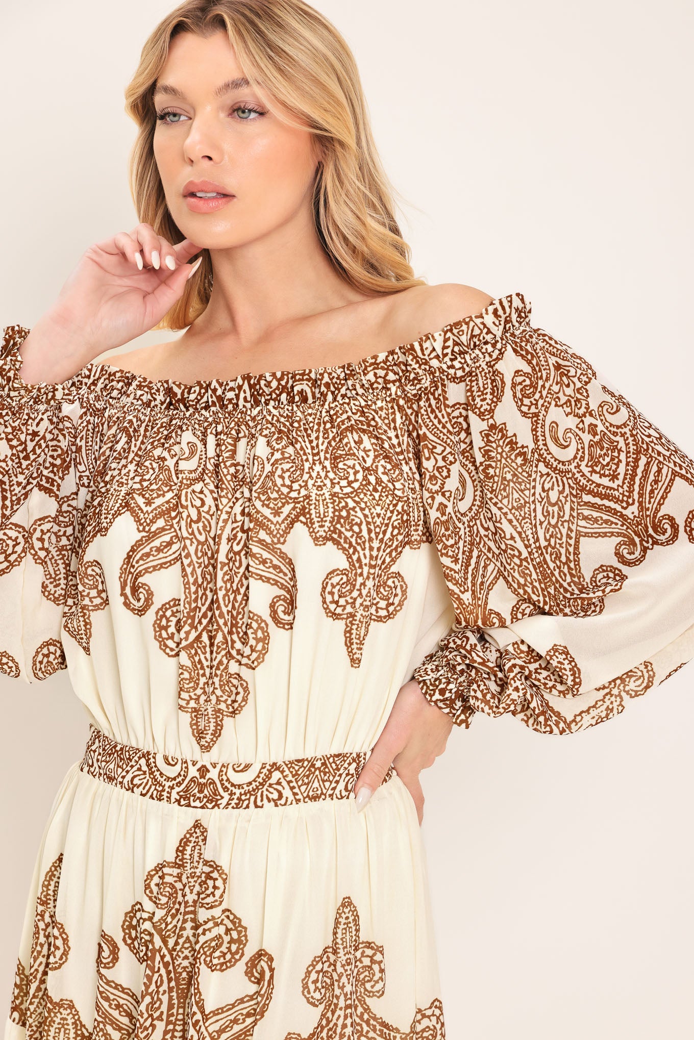 Woman wearing an off-shoulder maxi dress with intricate brown embroidery featuring a smocked back waistband | Flying Tomato