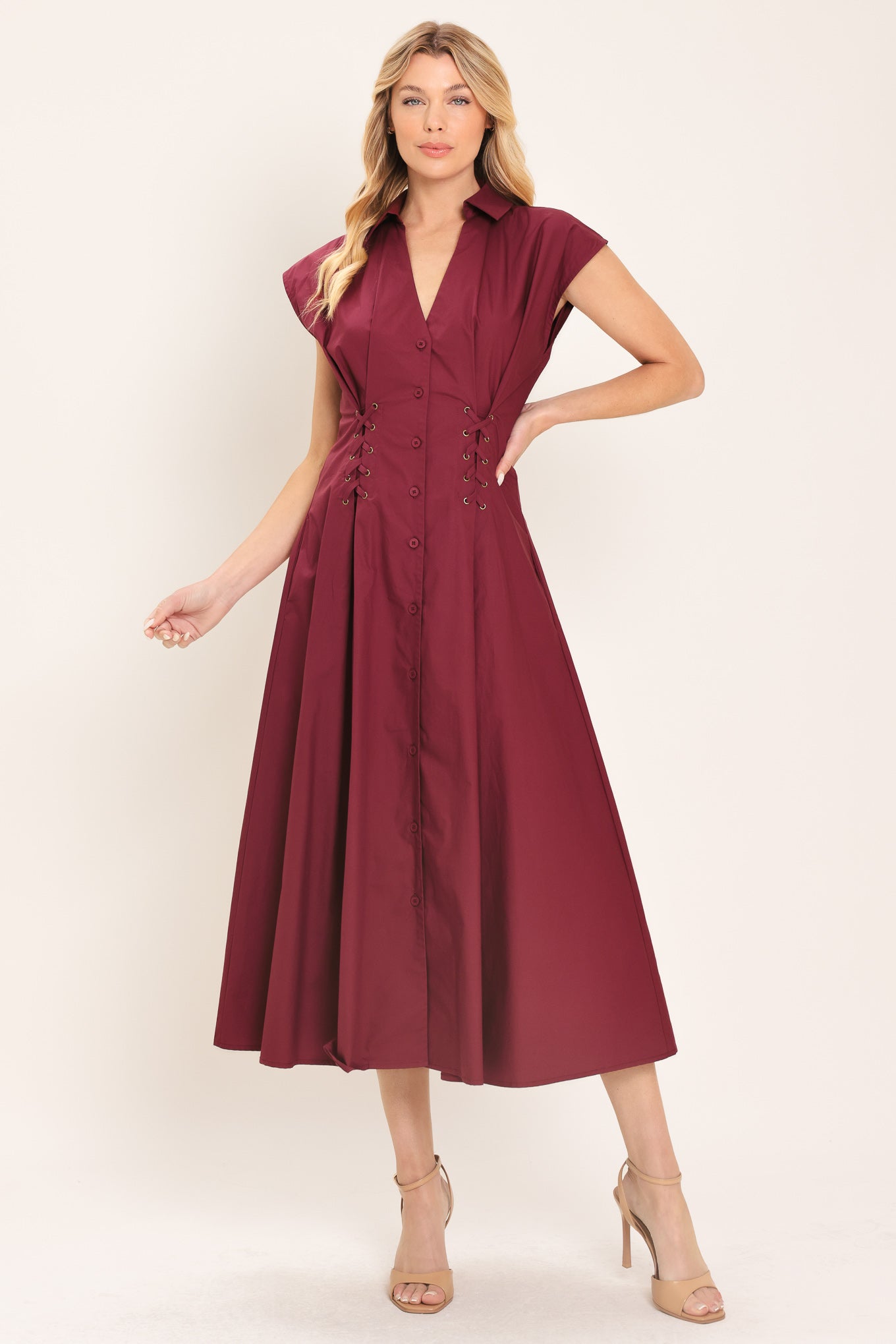Woman wearing a burgundy midi dress featuring V neckline with collared finish, short sleeve, lace up corset waist and front button down | Flying Tomato