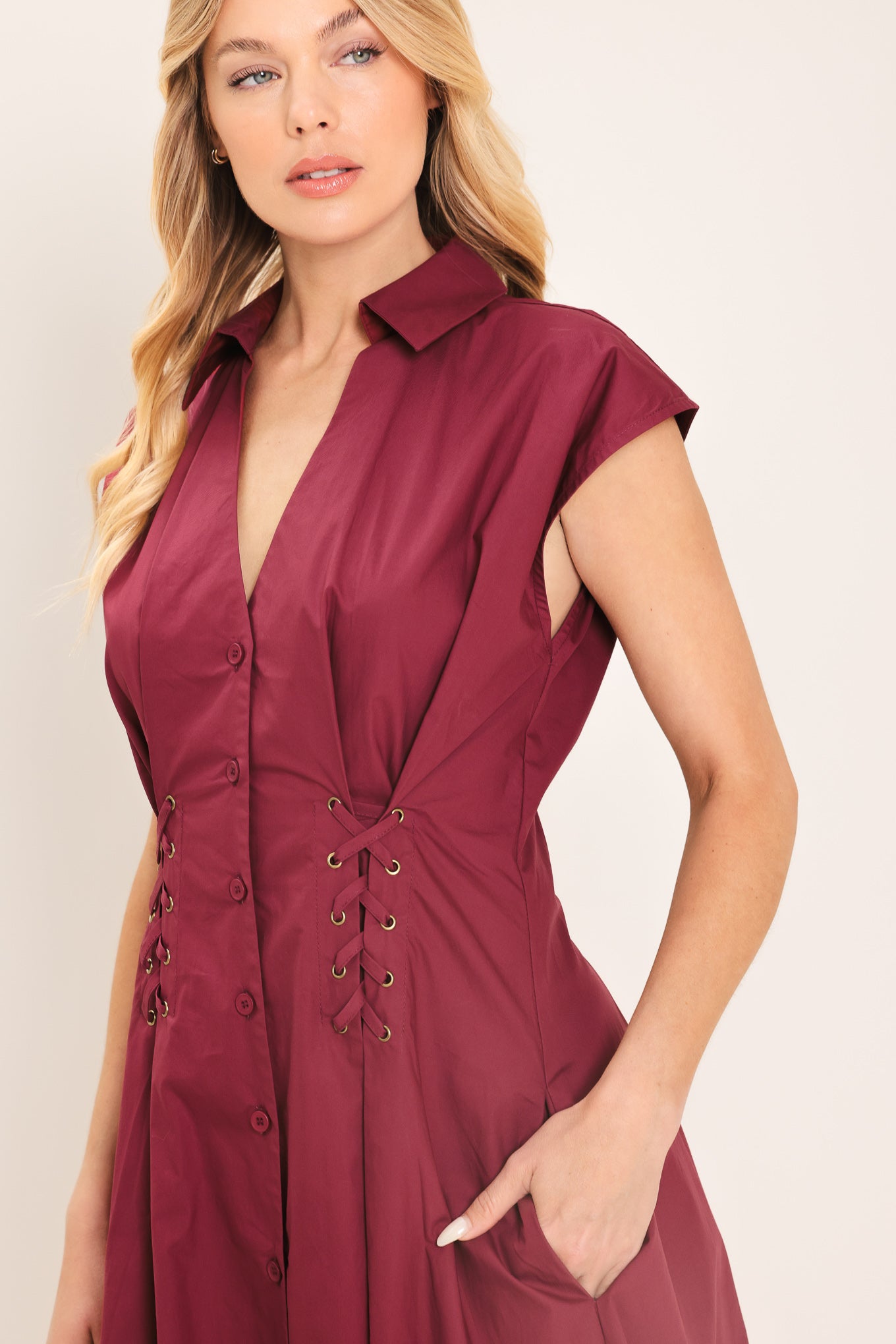 Woman wearing a burgundy midi dress featuring V neckline with collared finish, short sleeve, lace up corset waist and front button down | Flying Tomato