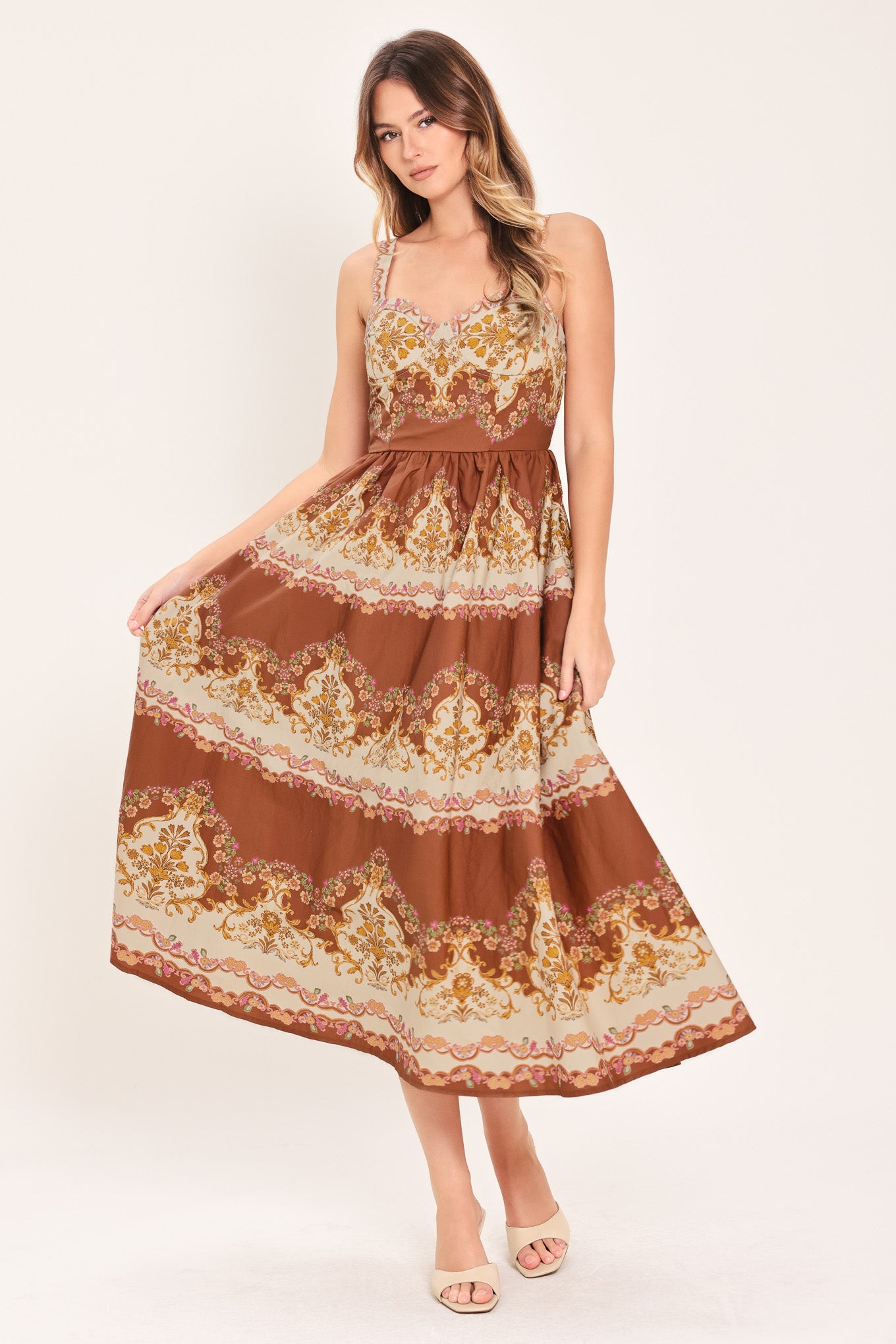 Woman wearing a brown floral midi dress featuring bustier top, straps, full skirt and smocked back bodice | Flying Tomato
