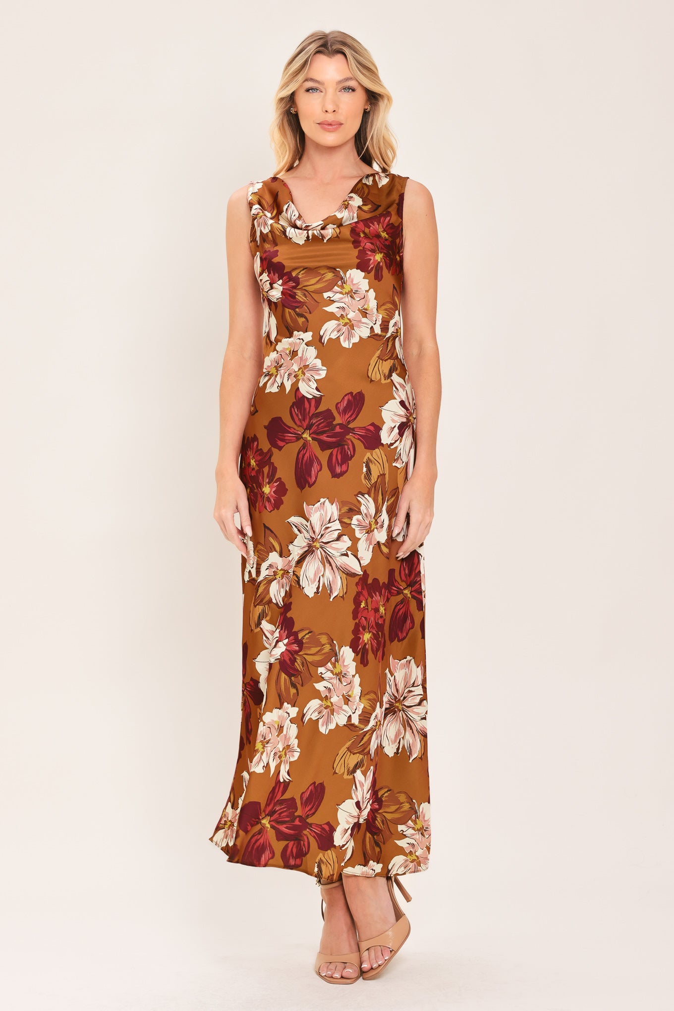 Woman wearing a caramel colored with floral printed woven midi dress featuring cowl neckline, sleeveless, circle skirt and twisted strap at back | Flying Tomato