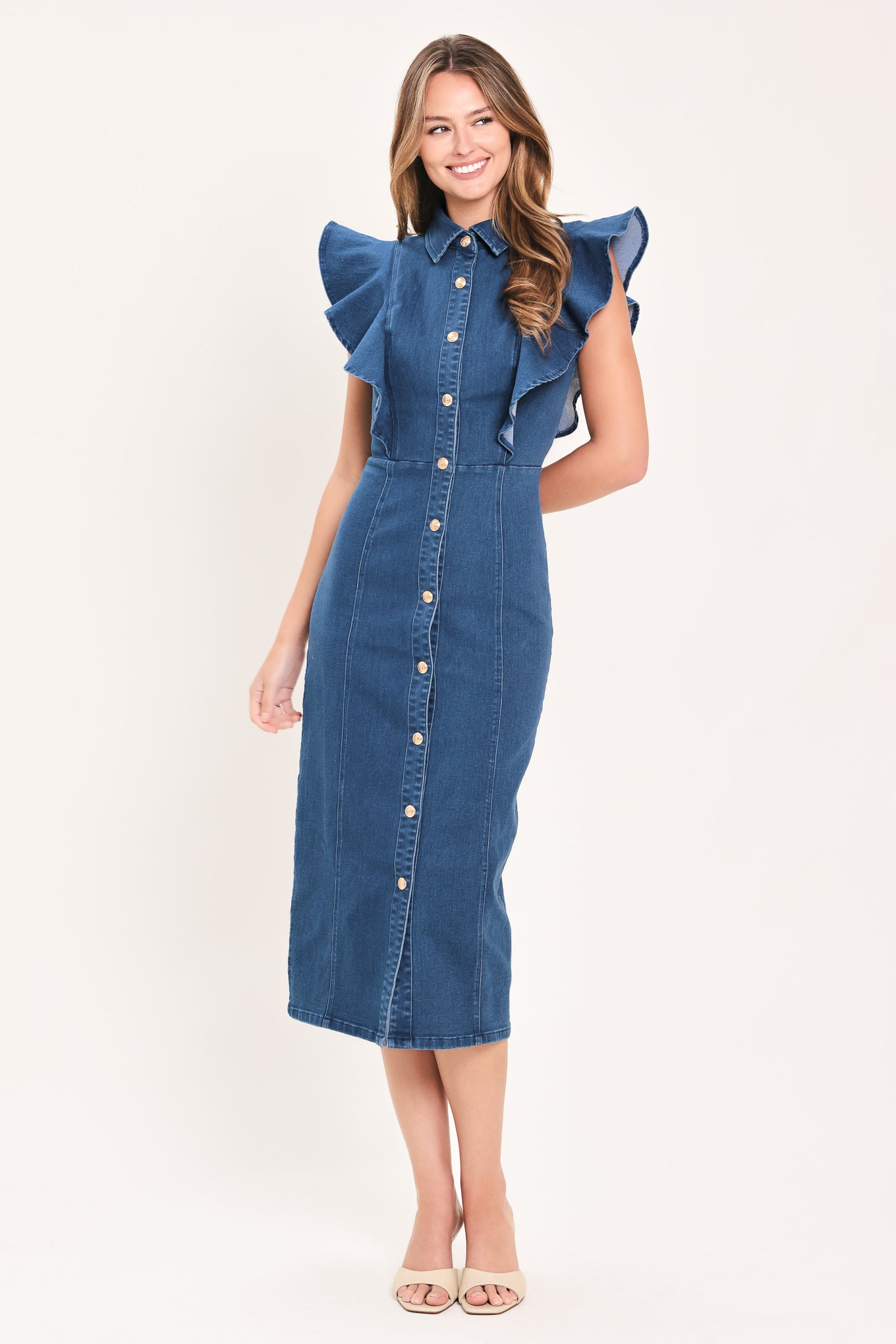 A woman wearing a blue denim midi dress with ruffled cap sleeves, a button-down front, and a pointed collar | Flying Tomato