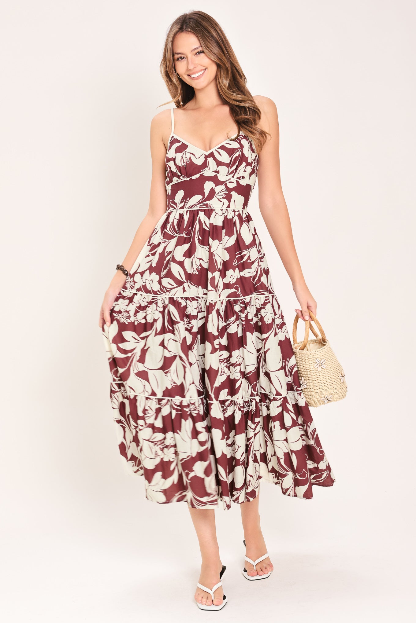 Woman wearing a floral maroon midi dress featuring cami top, waist yoke, tier skirt and smocked back bodice | Flying Tomato