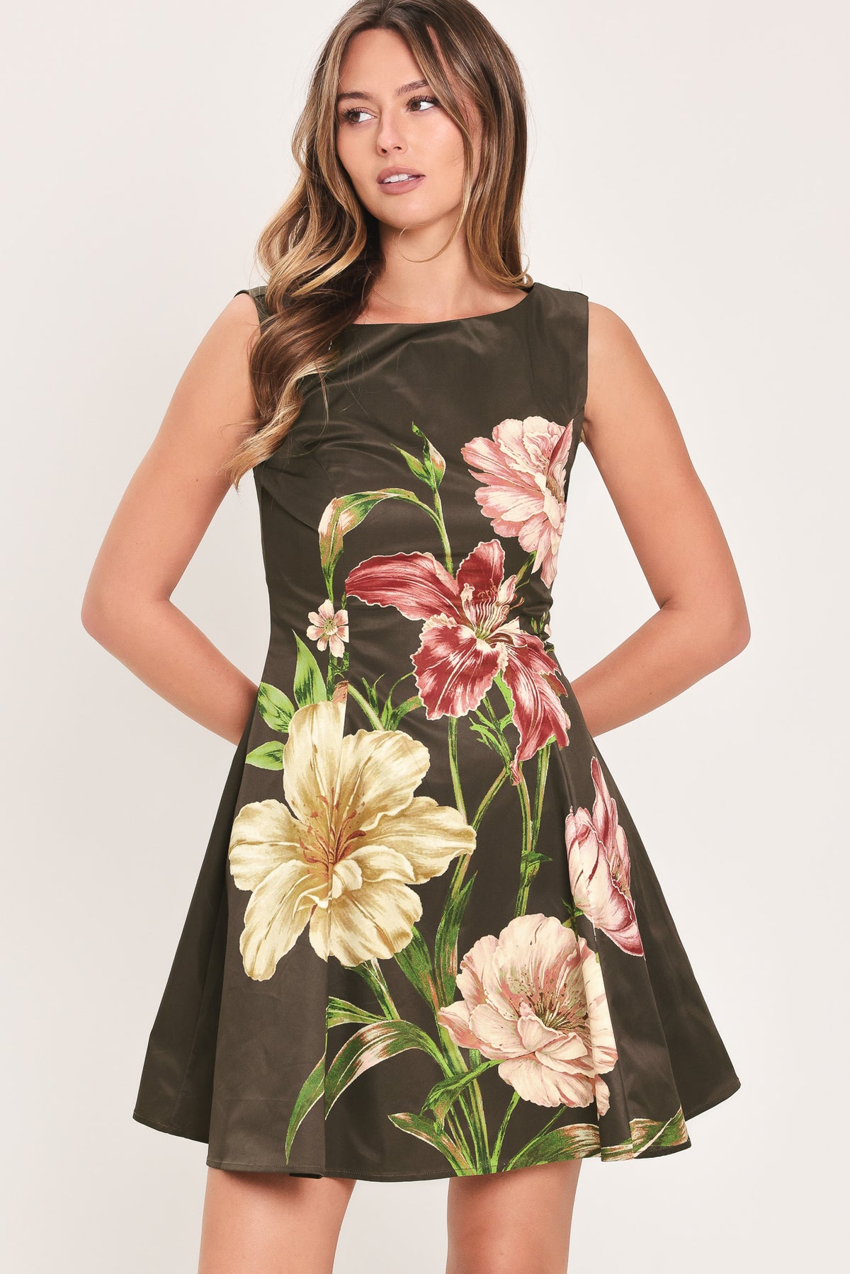 Woman wearing a sleeveless dark brown mini dress with a beige, pink, and burgundy floral print | Flying Tomato