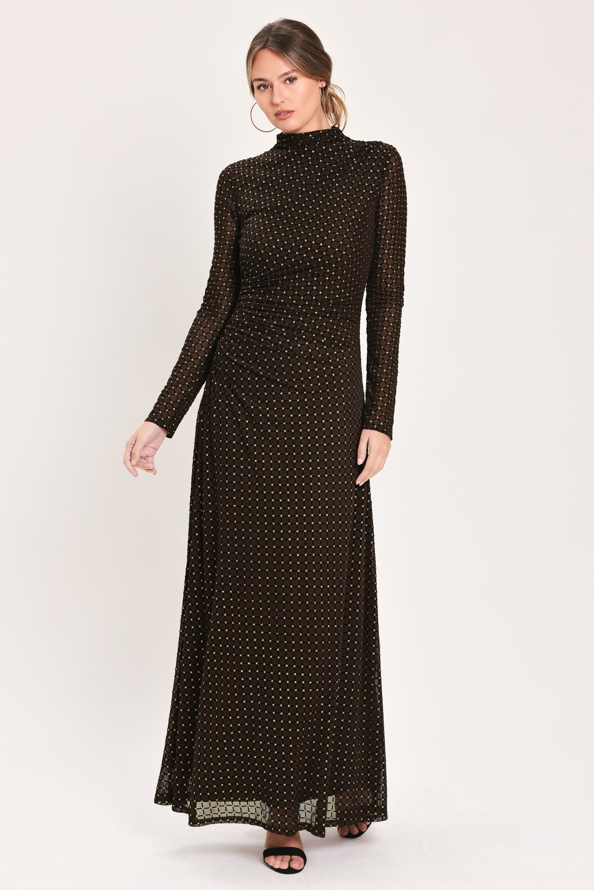 Woman wearing a long sleeve dark brown mesh maxi dress with gold tone rhinestones | Flying Tomato