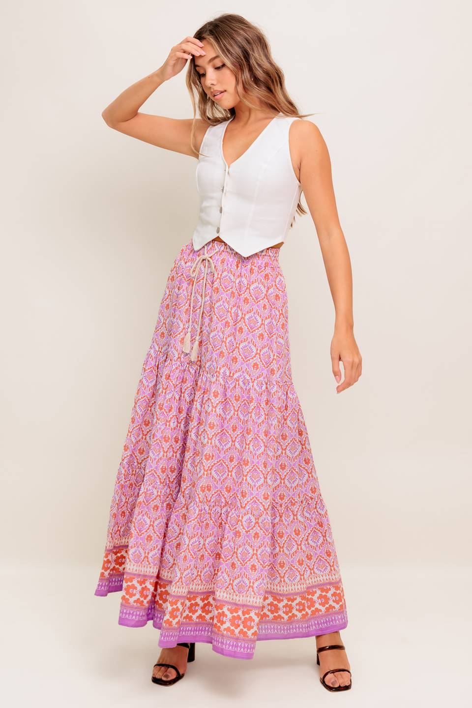 A printed woven maxi skirt featuring elasticized waist with contrasting tie and tiered bottom.