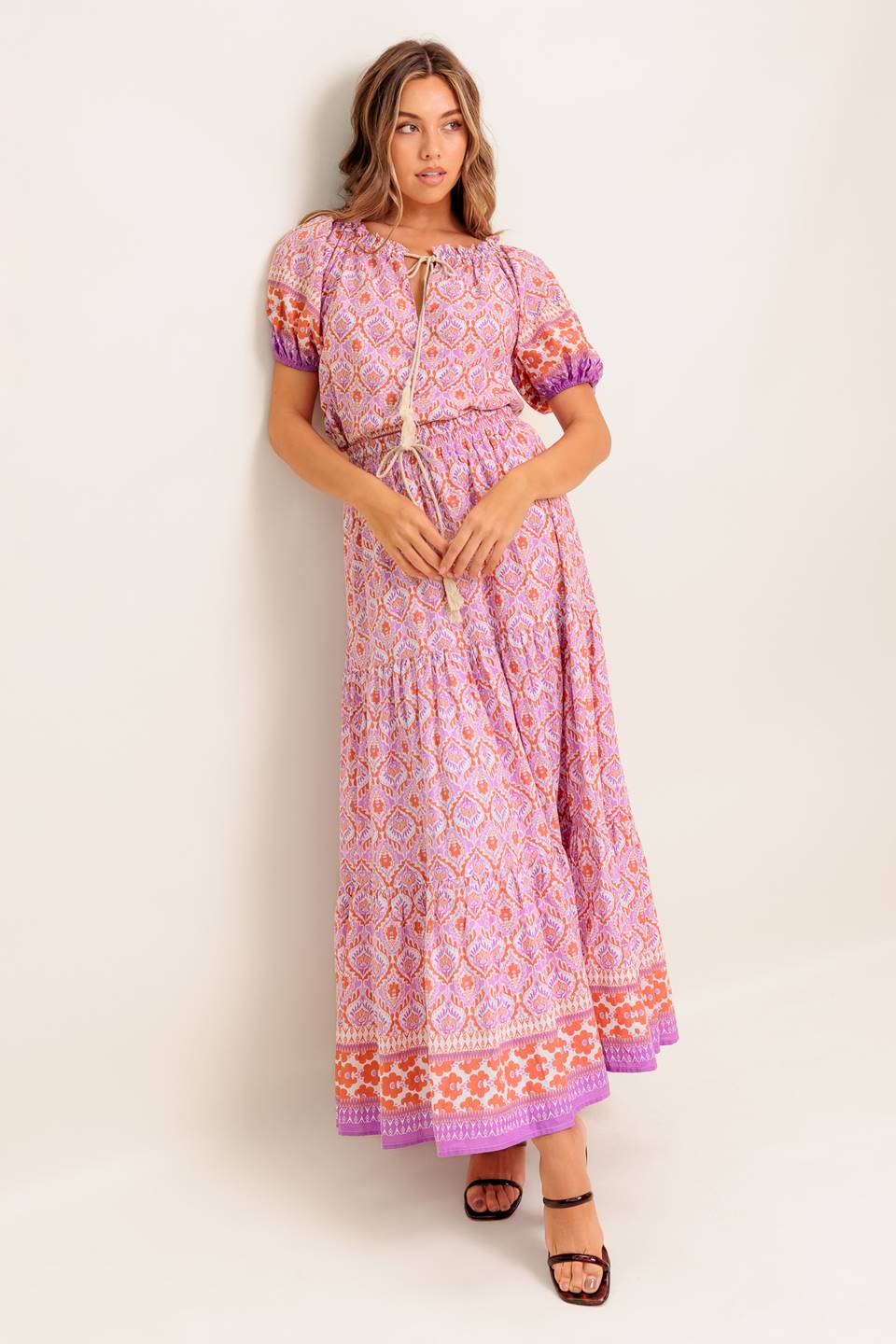 A printed woven maxi skirt featuring elasticized waist with contrasting tie and tiered bottom.