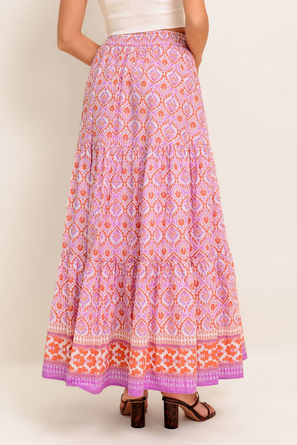 A printed woven maxi skirt featuring elasticized waist with contrasting tie and tiered bottom.