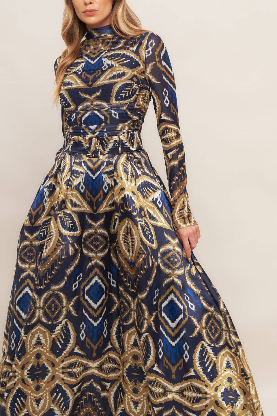 A printed woven maxi full skirt with side zipper closure and self belt.