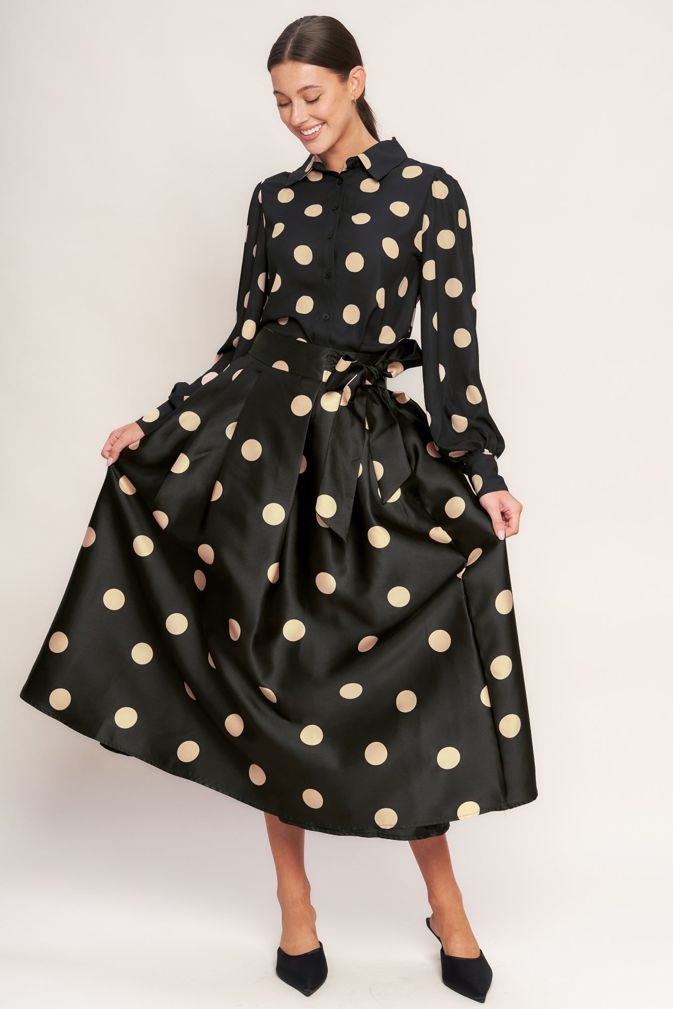 A polka-dotted printed woven full midi skirt featuring side zipper closure with tie.