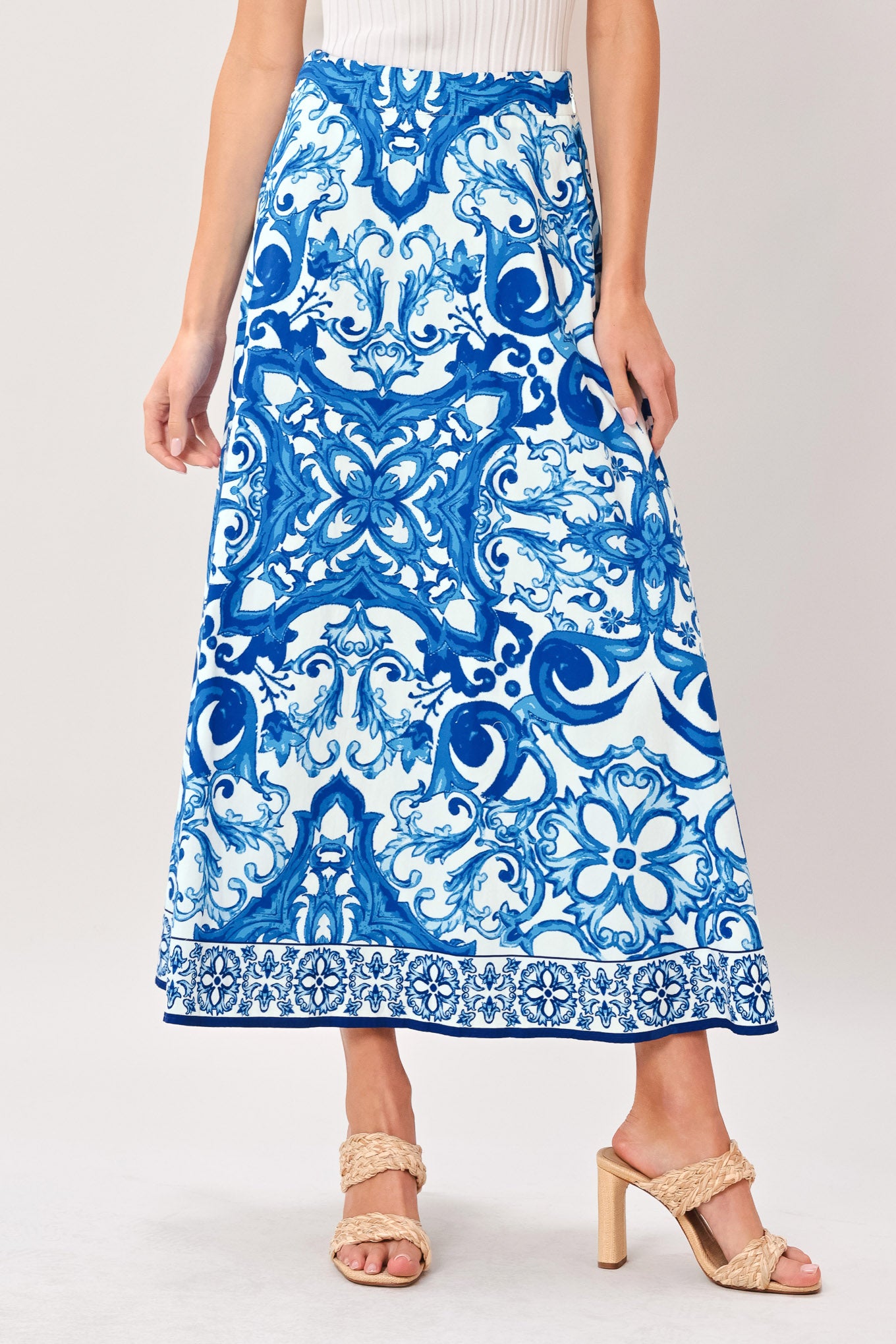 Woman wearing a blue and white patterned midi circle skirt with side zipper closure | Flying Tomato
