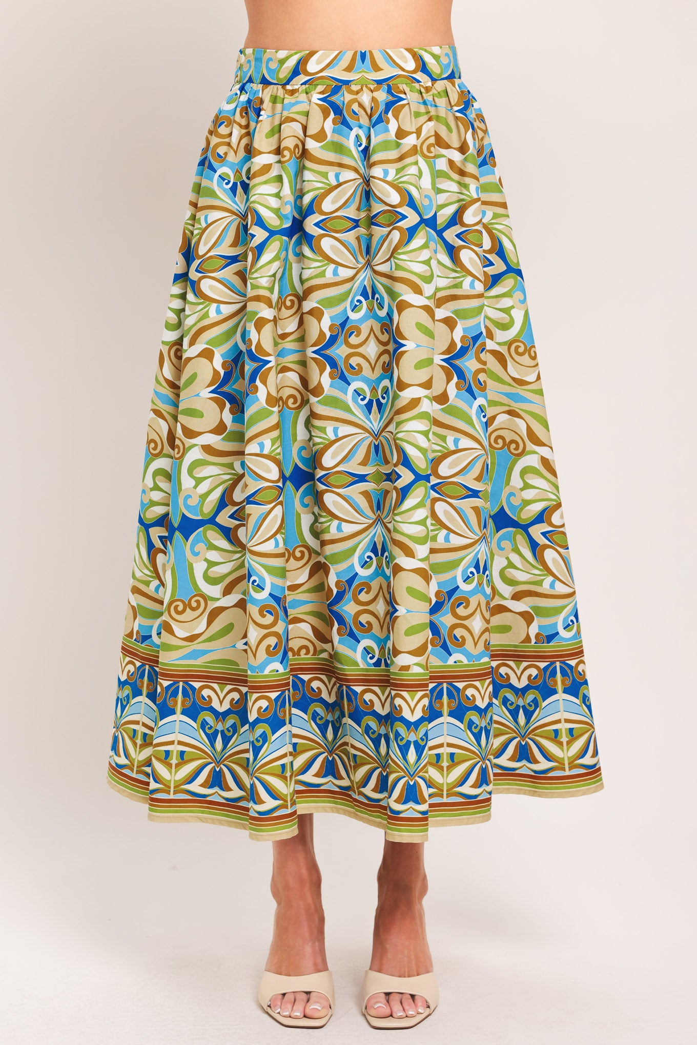 Woman wearing patterned full skirt with blue, green, and beige colors with elastic back waistband | Flying Tomato