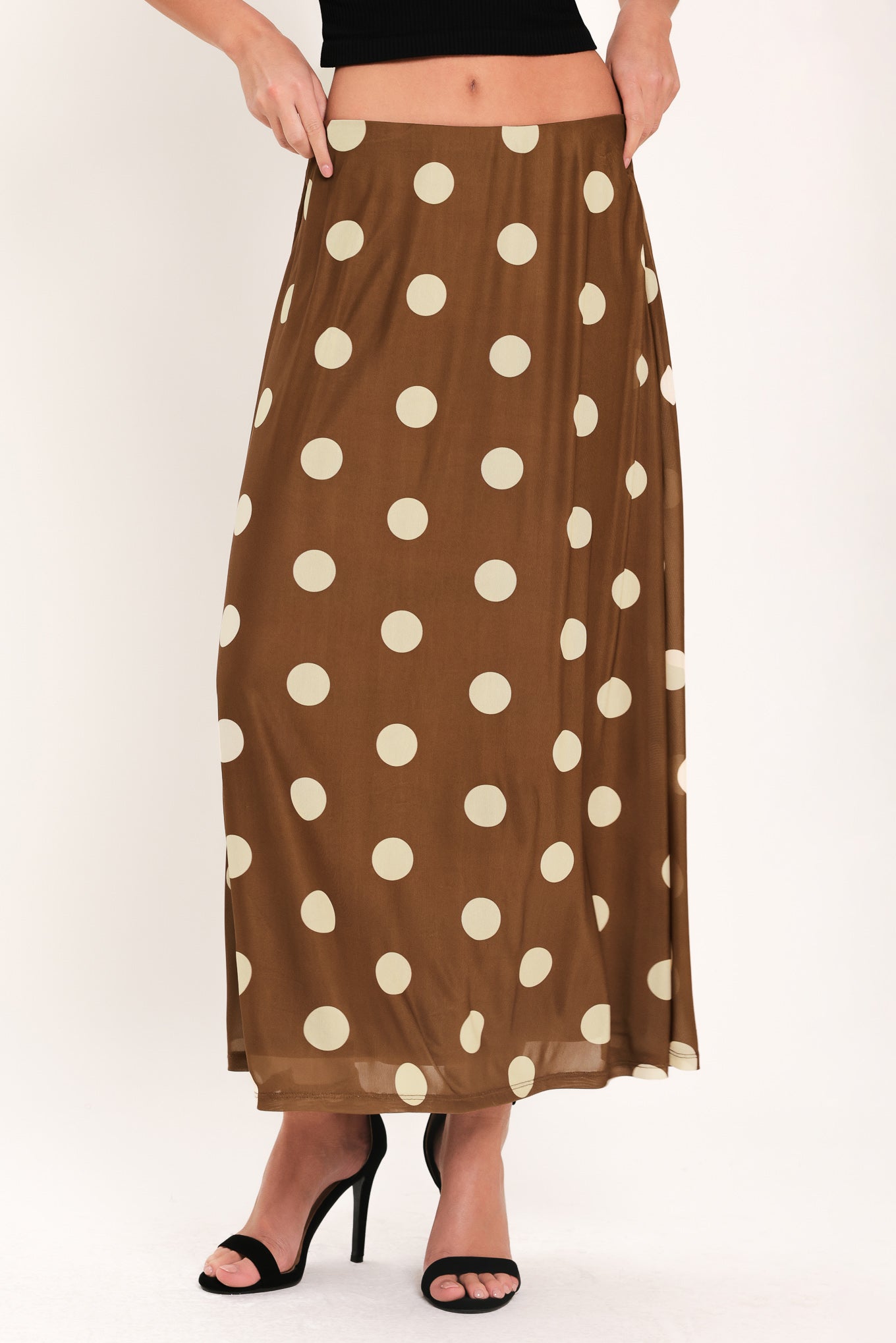 Woman wearing a brown polka dot midi skirt with elastic waist | Flying Tomato