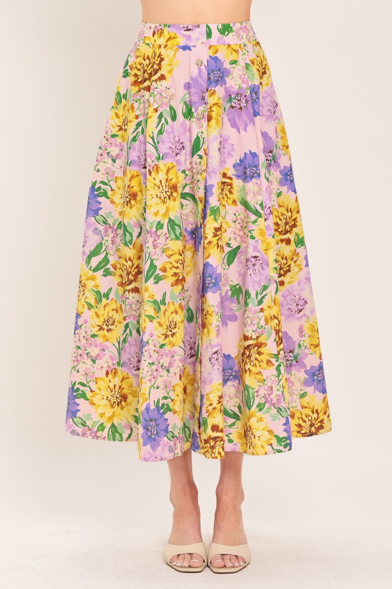 Woman wearing a yellow and purple floral patterned full midi skirt with front button detail and smocked back waistband | Flying Tomato
