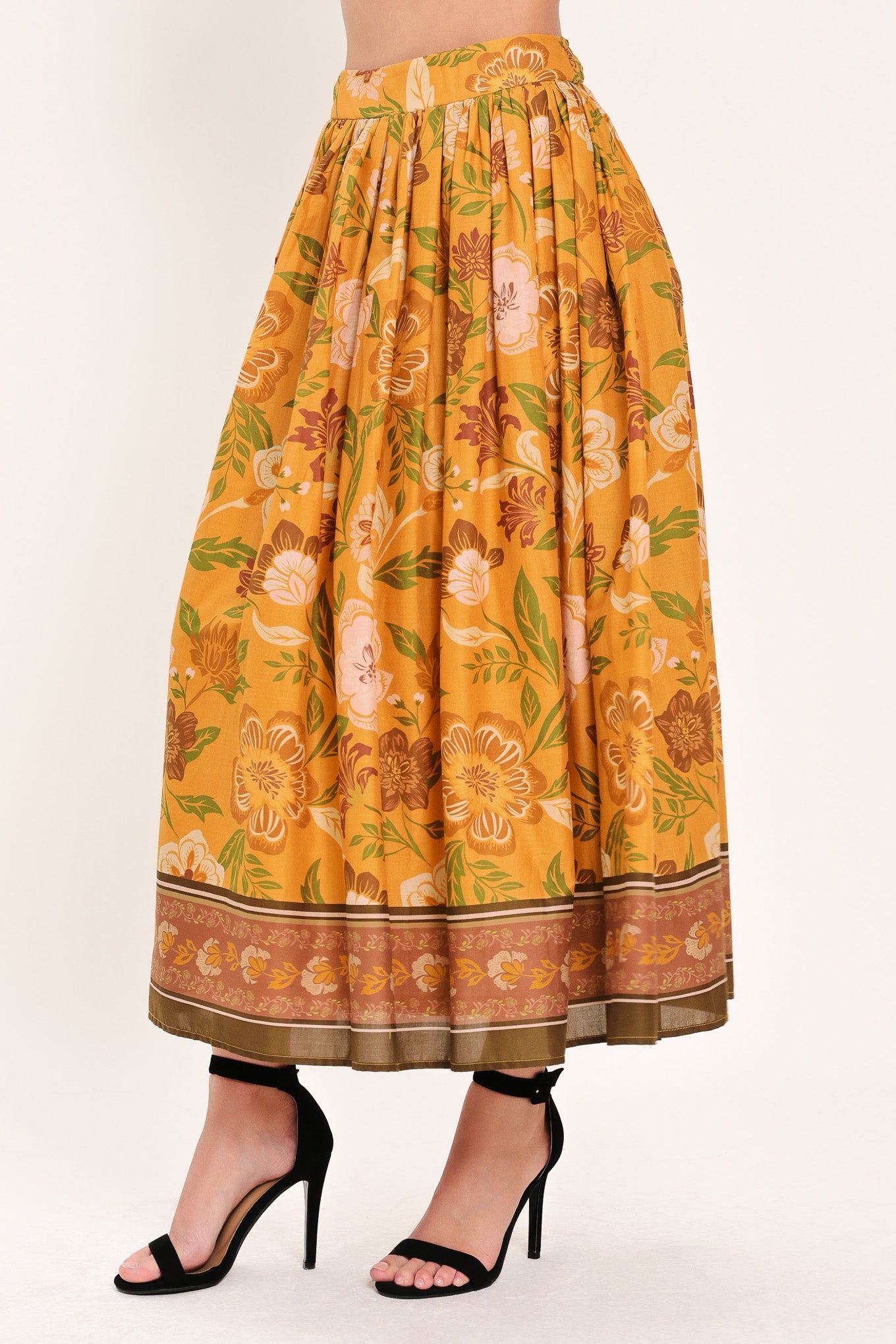 Woman wearing a mustard yellow floral patterned midi skirt | Flying Tomato