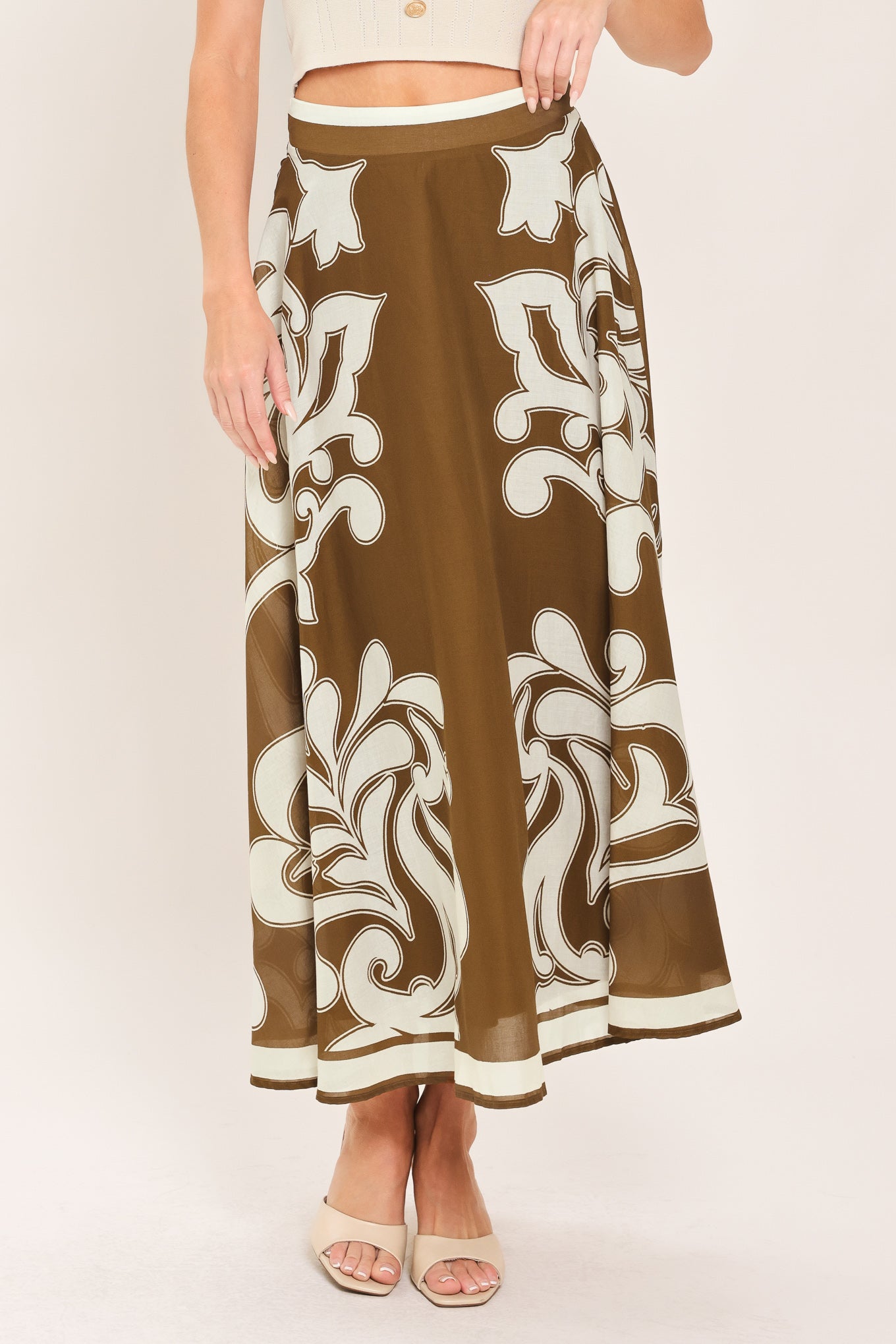 A woman wearing a brown midi skirt with a large white baroque pattern | Flying Tomato