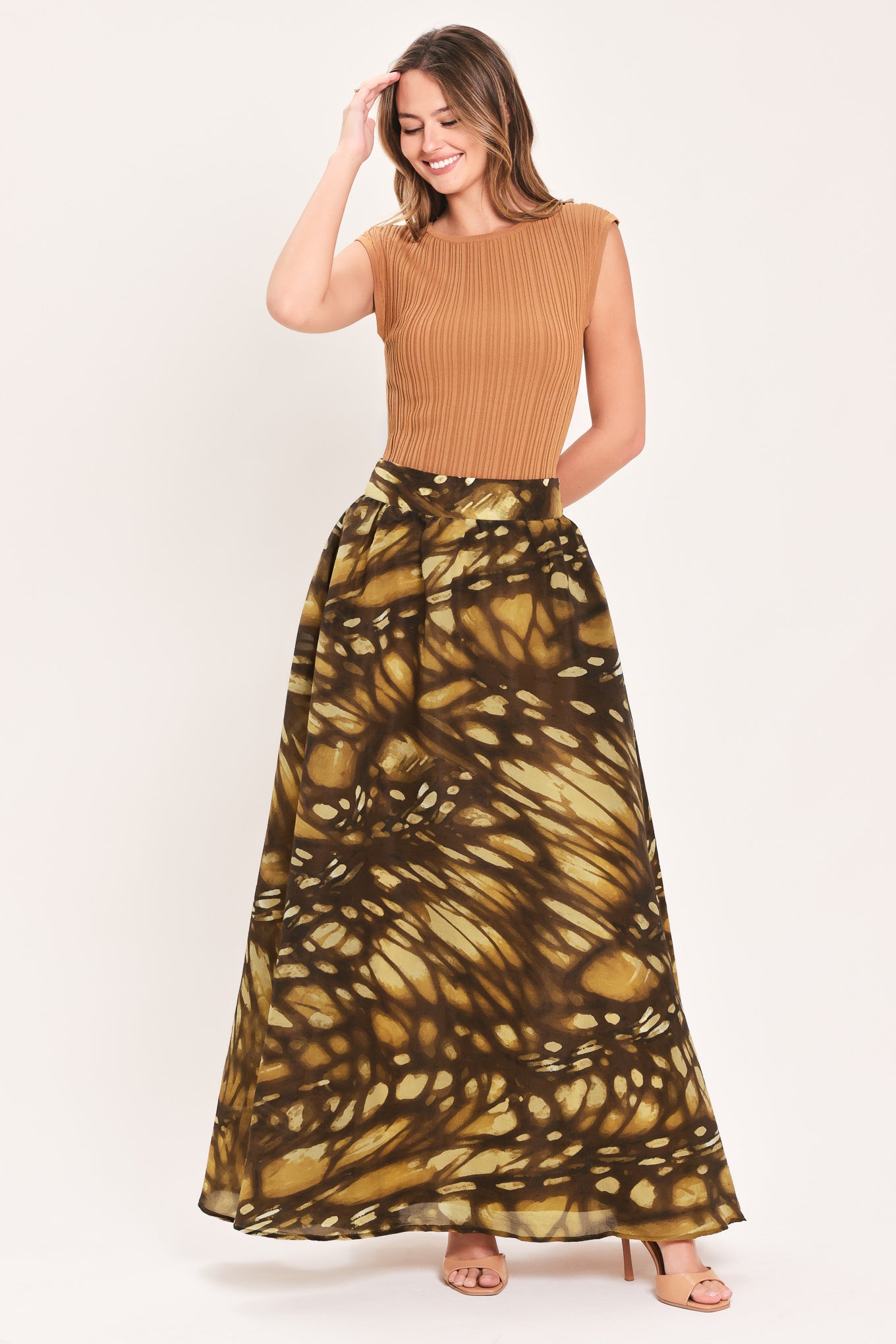 A woman wearing a dark brown maxi skirt with a butterfly-like pattern | Flying Tomato