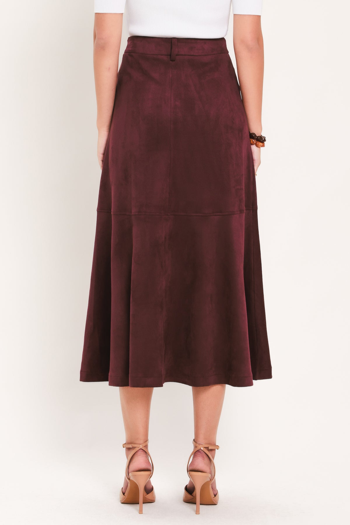 A woman modeling a high-waisted, midi A-line skirt in a deep burgundy suede-like fabric | Flying Tomato