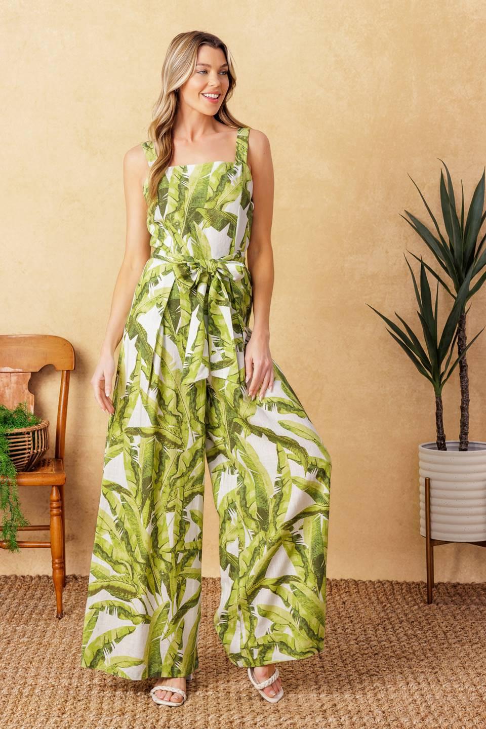 A printed woven jumpsuit featuring straight neckline, straps, self sash tie, wide leg with front pleat and back zipper closure