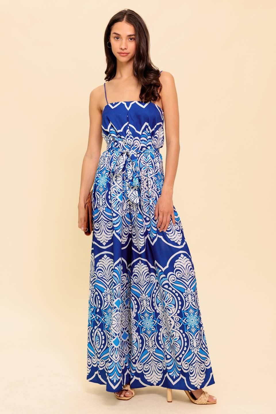 A printed woven jumpsuit featuring straight neckline, skinny straps, self sash belt and wide leg