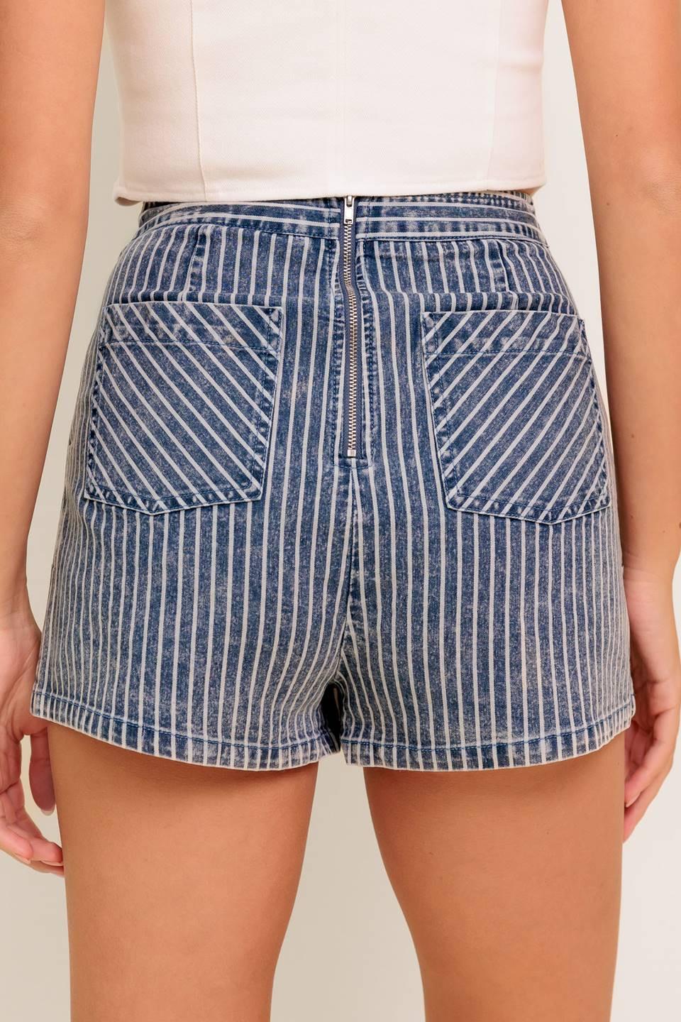 A striped denim featuring front button detail, back pocket and zipper closure