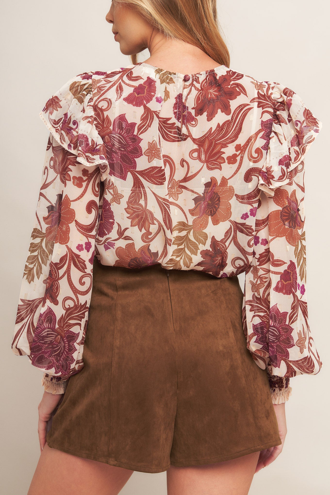 A faux suede skort featuring front slit and back zipper closure