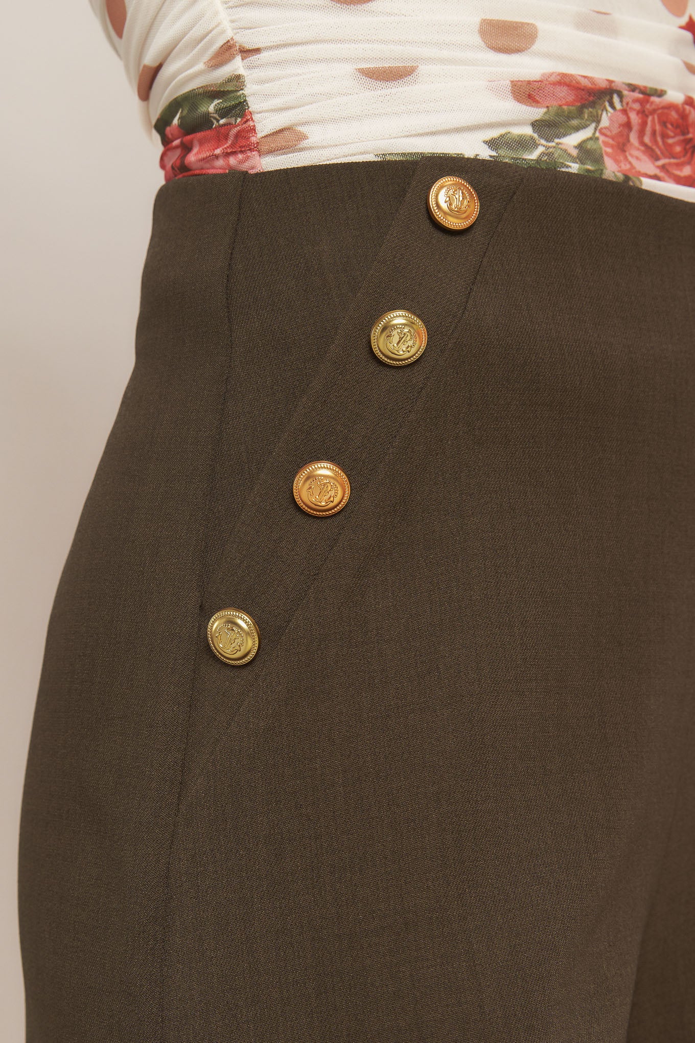 A solid woven pant featuring side button detail, wide leg and side zipper closure