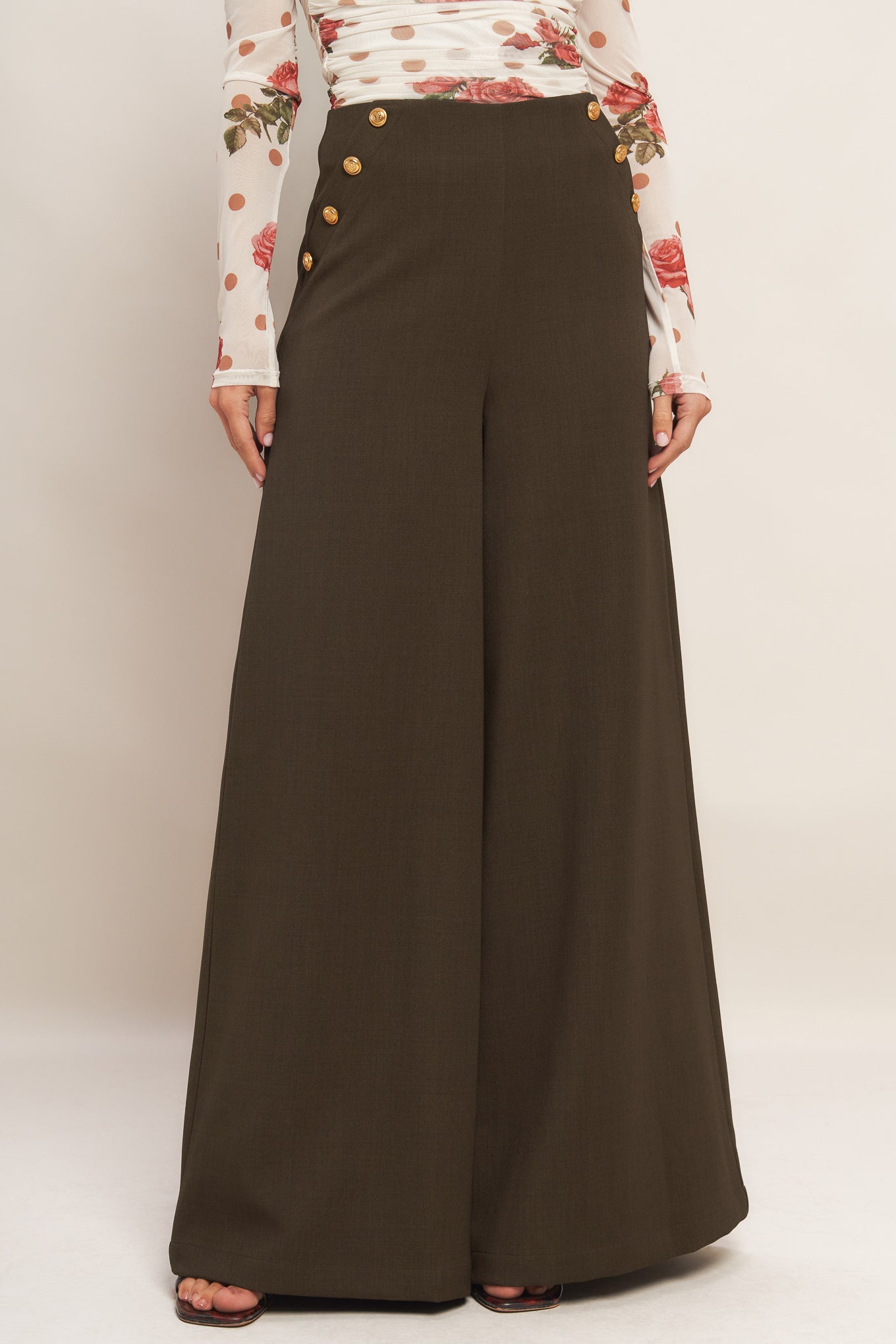 A solid woven pant featuring side button detail, wide leg and side zipper closure