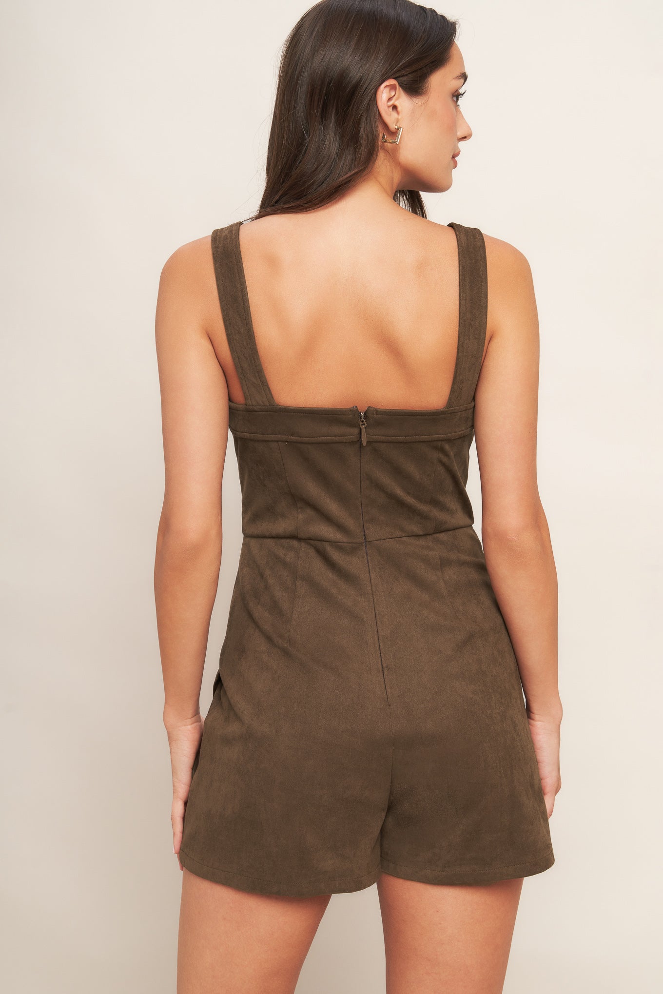 A faux suede romper featuring straight neckline, straps, skort bottom and back zipper closure
