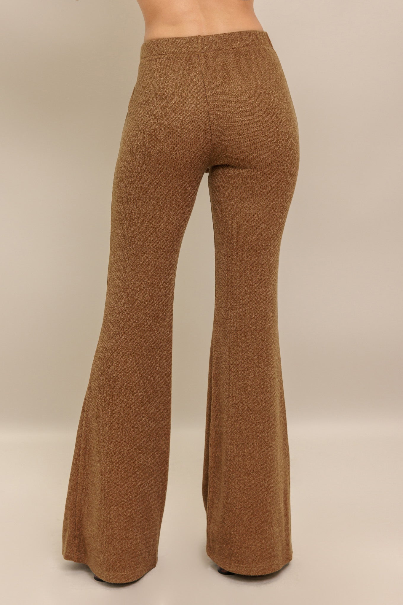 A solid knit pant featuring elasticized waist, flare leg and tassel tie.