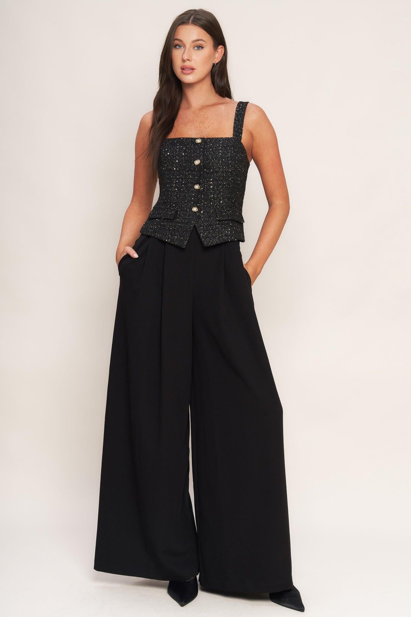 A woven jumpsuit featuring tweed bodice with straight neckline and strap, button down detail, solid woven wide leg pant and back zipper closure