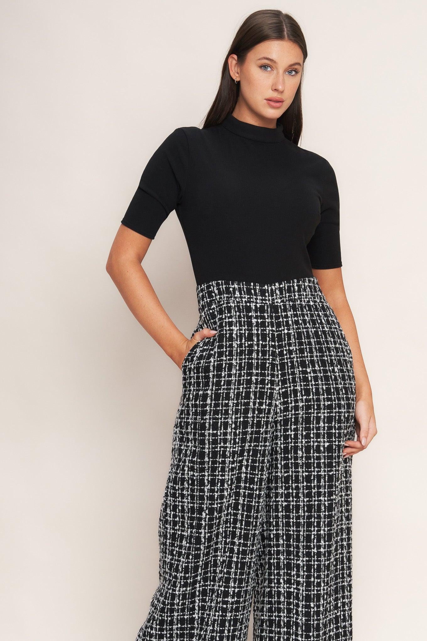 A ribbed knit top and tweed pant jumpsuit featuring mock neckline, short sleeve, side leg and back zipper closure
