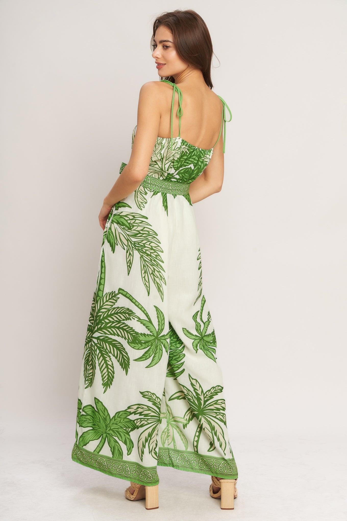 Woman wearing a green and white leaf-patterned dress on a plain background