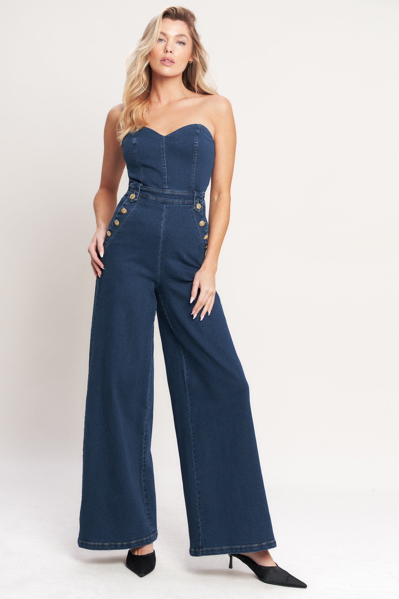 A washed denim jumpsuit featuring strapless, sweetheart neckline, side pockets with buttons, wide leg and back zipper closure
Details:
Self: 75% Cotton 23% Polyester 2% Spandex
Size & Fit
- Model is 5`8" And Wearing Size Small
- Measurements Taken From Size Small
- Approx. Length: 54"