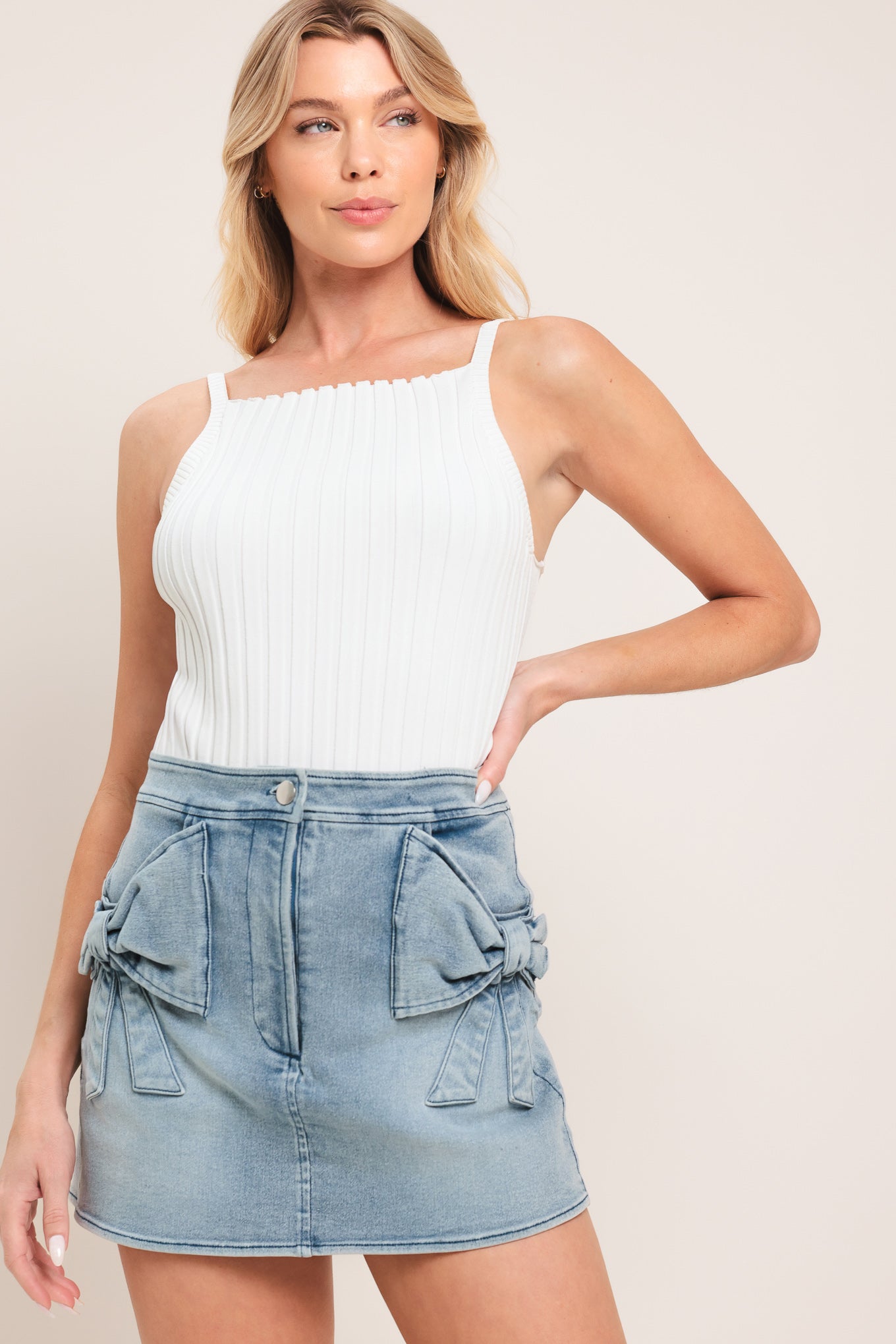 Woman wearing a light blue denim denim skort with front closure and bow pockets | Flying Tomato