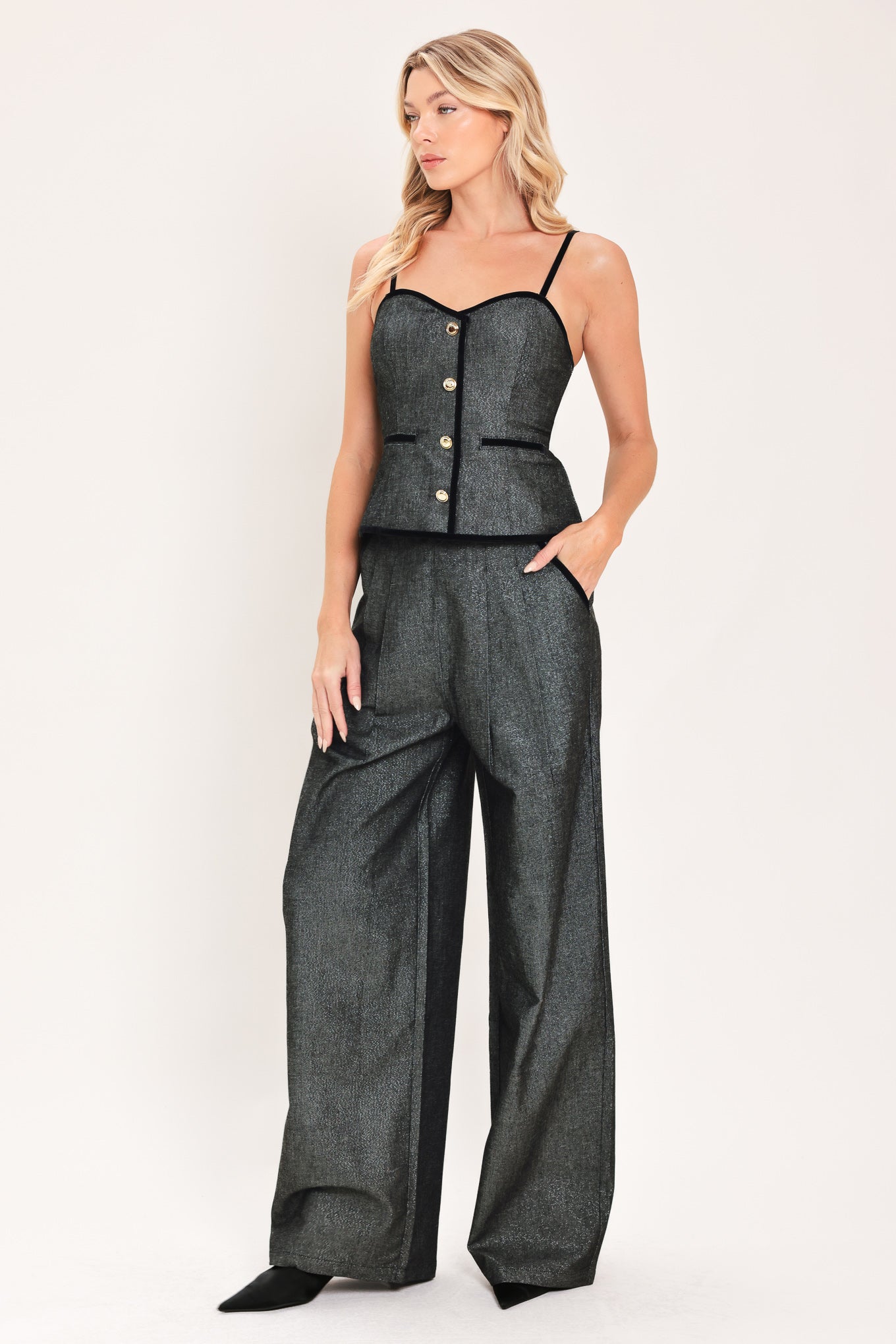A pair of wide-leg trousers in a black denim textured fabric, shown on a model | Flying Tomato