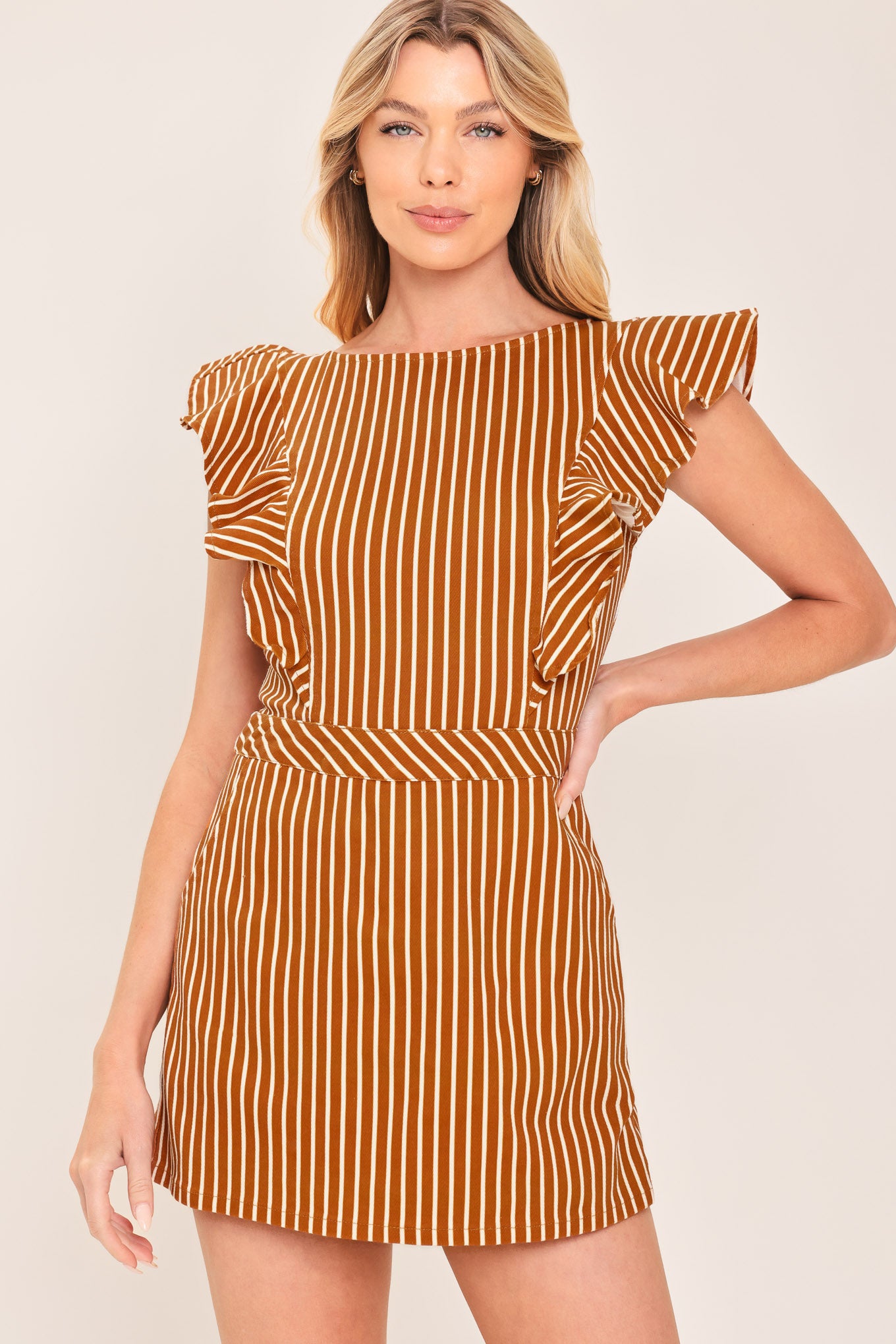A woman wearing a mini skort romper with vertical rust and white stripes | Flying Tomato