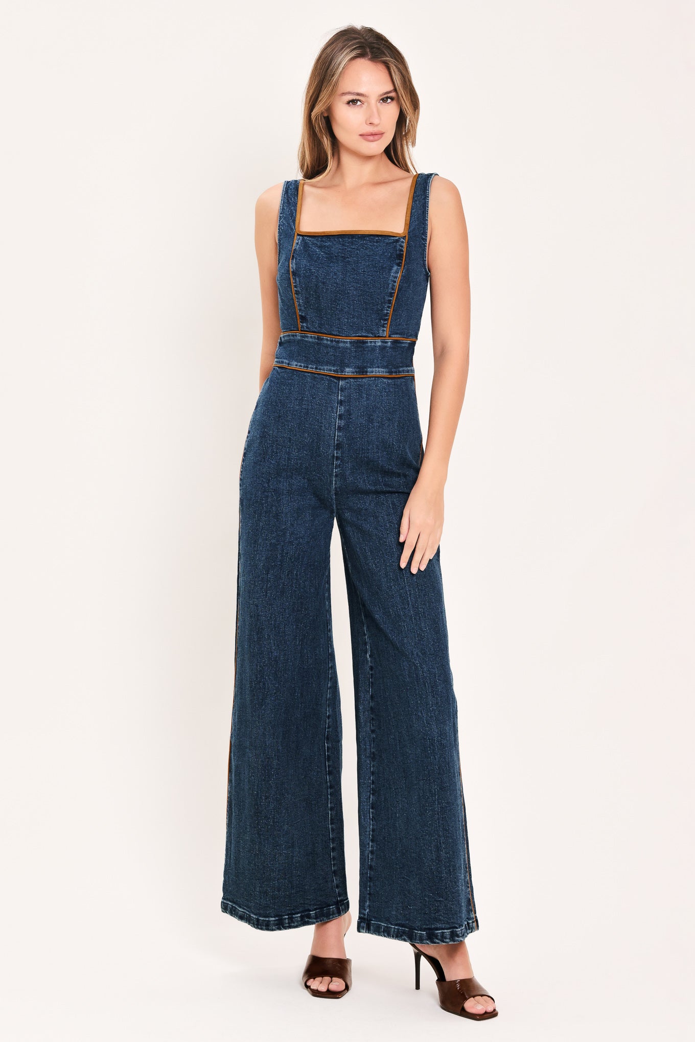 A woman modeling a dark blue denim wide-leg jumpsuit with square neckline | Flying Tomato