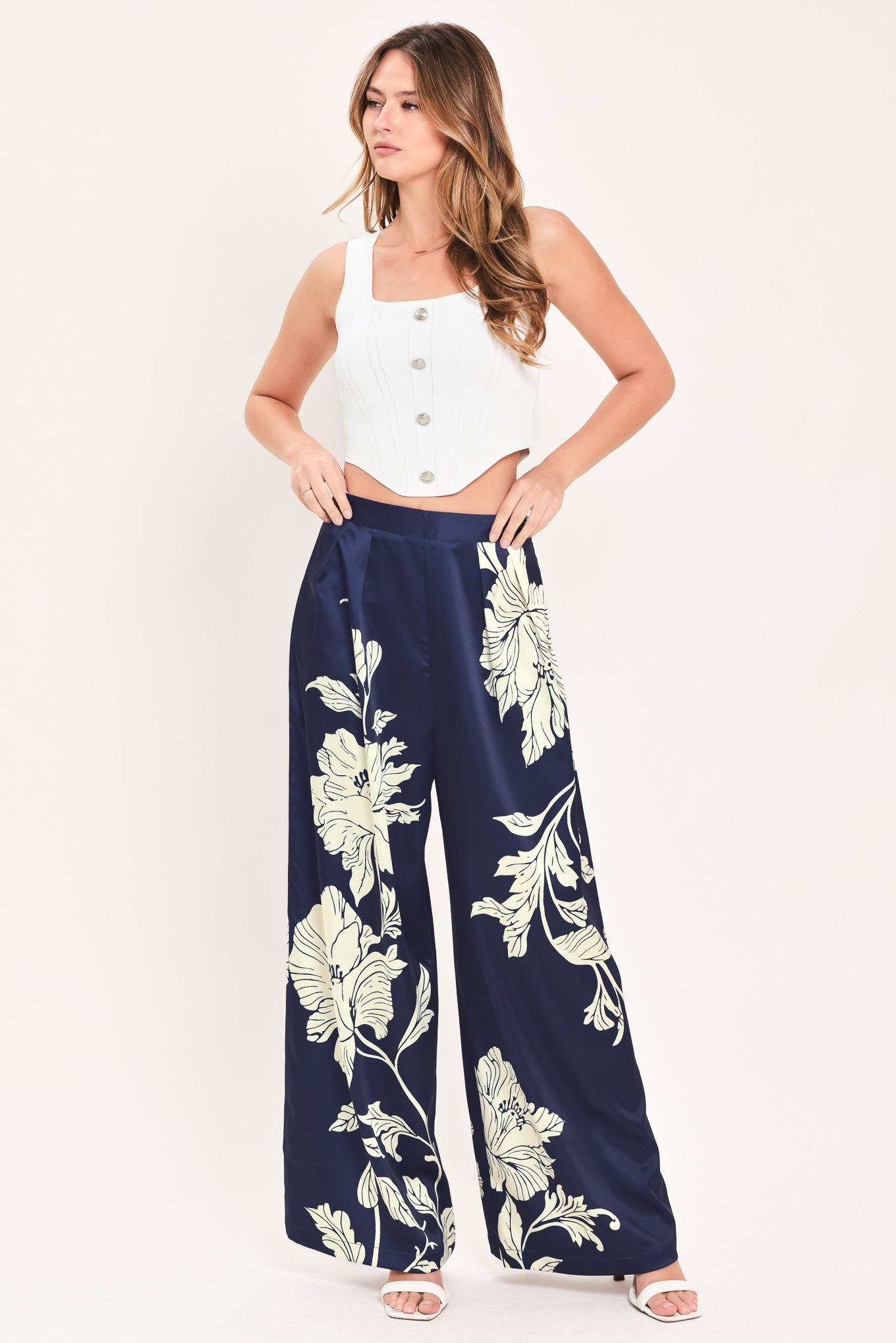 A woman wearing navy blue wide-leg pants with a large cream floral print | Flying Tomato