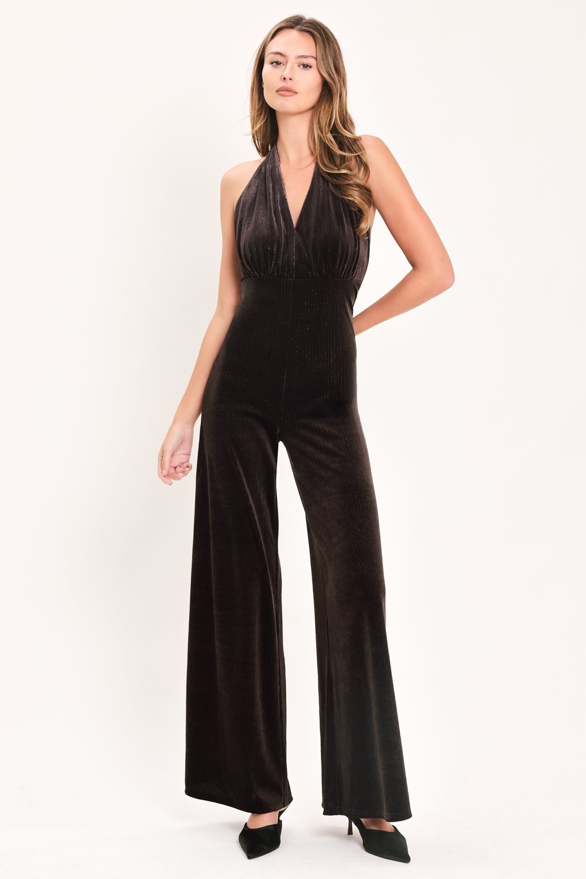 Woman wearing a brown velvet halter, backless jumpsuit | Flying Tomato