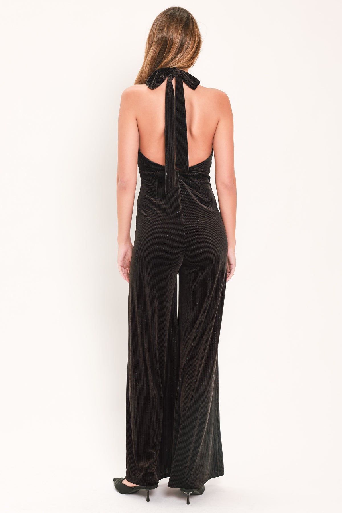 Woman wearing a brown velvet halter, backless jumpsuit | Flying Tomato