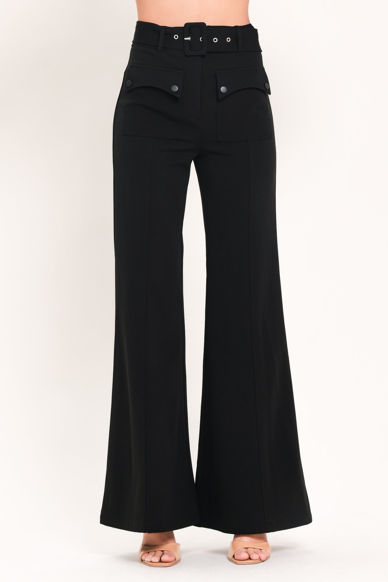 Woman wearing a pair of black pants with a belt and front pockets | Flying Tomato
