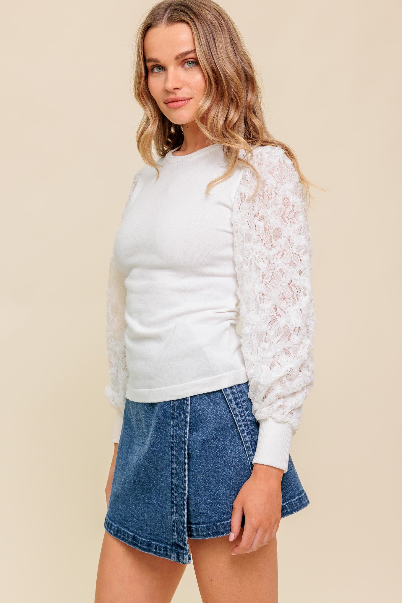 A sweater knit top featuring round neckline with contrasting sleeve