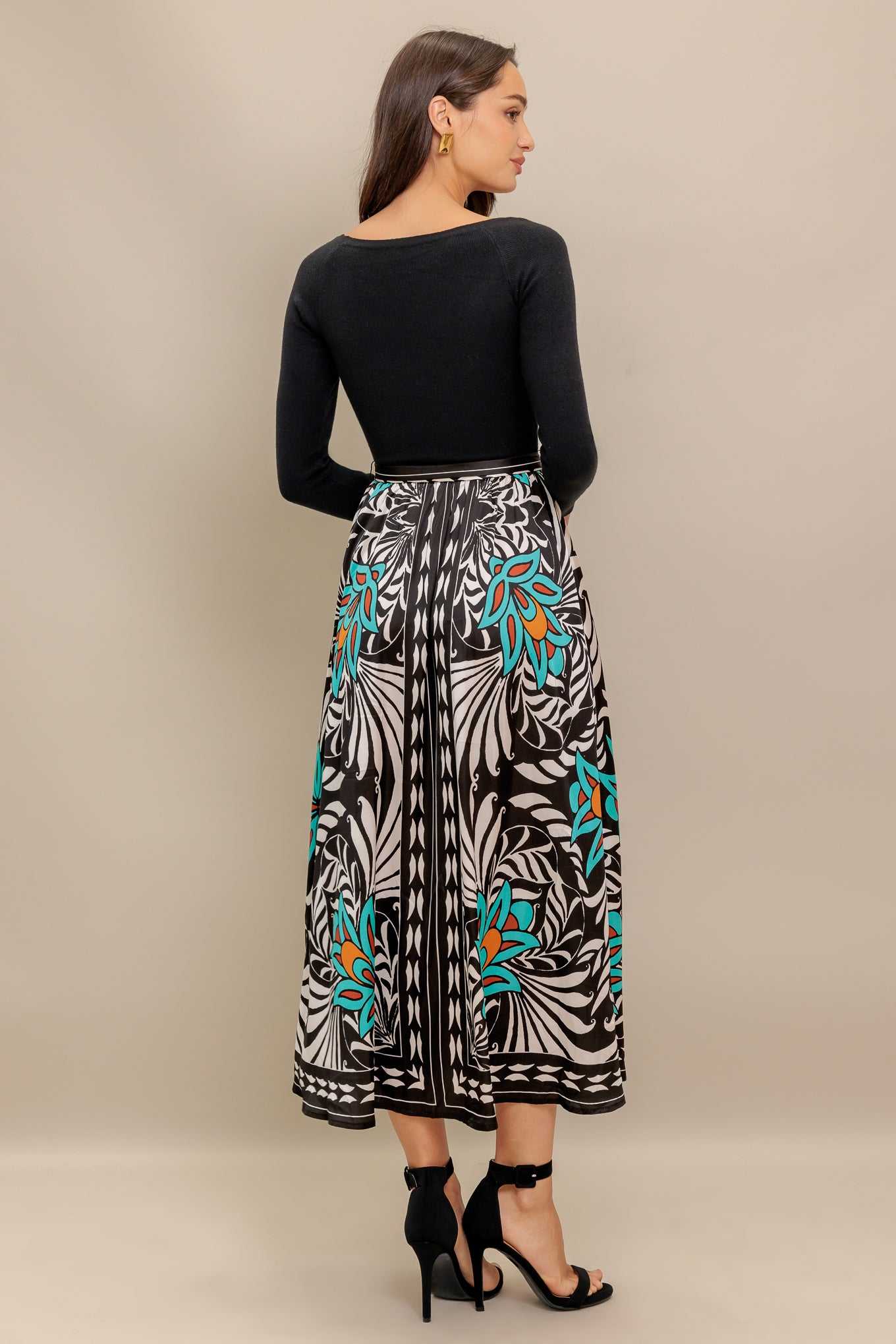 A midi dress featuring sweater top with long sleeve, self sash and printed woven skirt