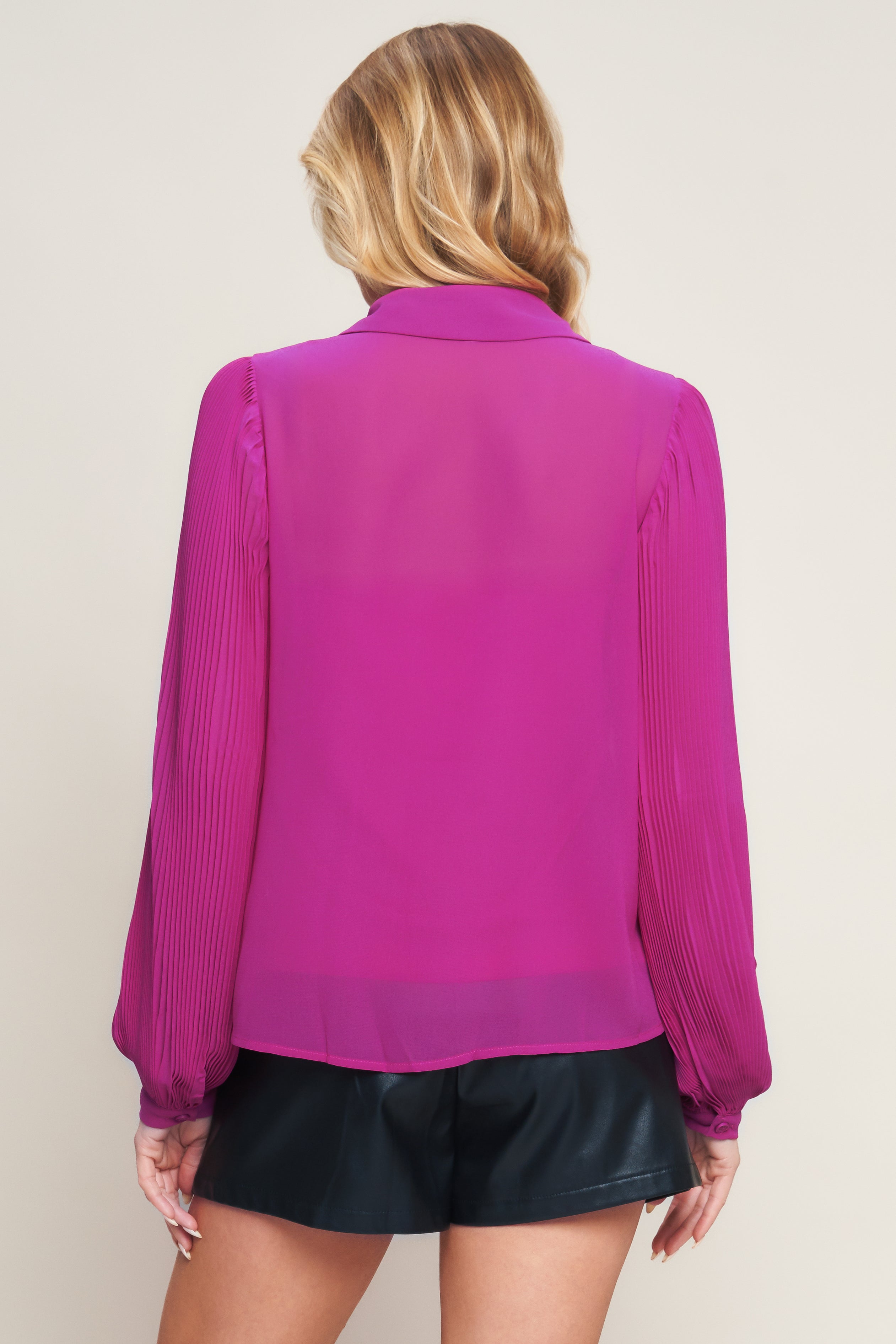 A solid woven top featuring shirt collar, button down, long baby pleated sleeve with cuff