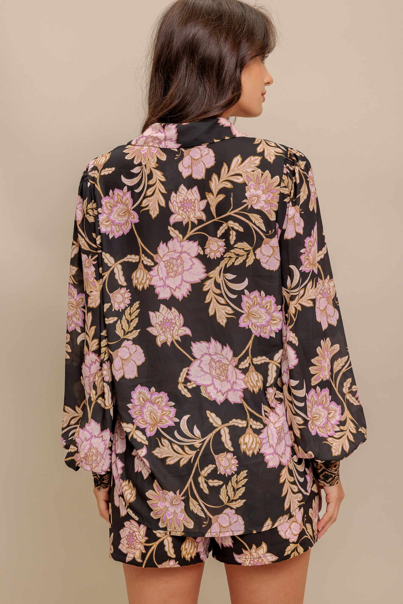 A printed woven top with front button down and long sleeve