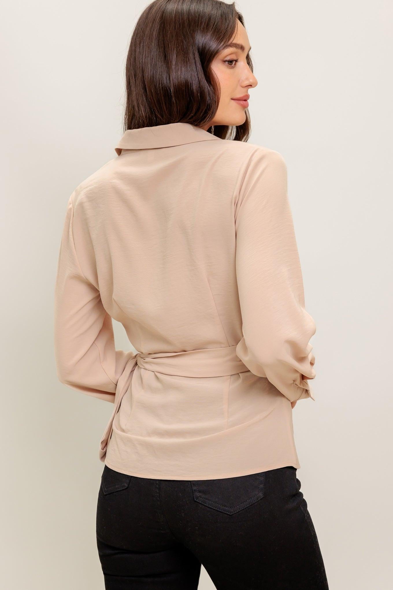 A solid woven top featuring collar, surplice neckline, long sleeve and true wrap