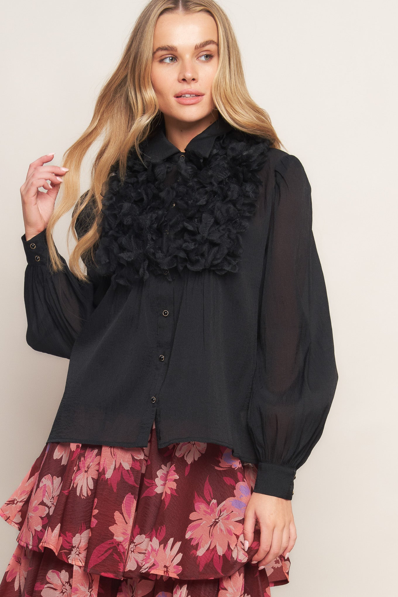 A solid woven top featuring shirt collar, button down, floral embellished front and long sleeve